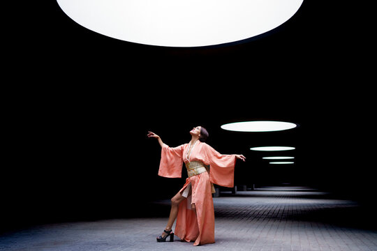 Woman wearing kimono and looking up at spotlight