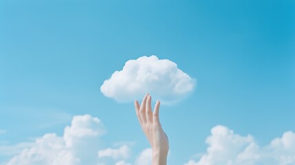 A conceptual image of a hand reaching towards a single, fluffy cloud against a clear blue sky, representing ideas of aspiration, imagination, and cloud computing technology. - obrazy, fototapety, plakaty