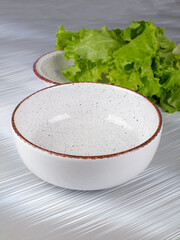 Ceramic clay plate with dark edging on gray background