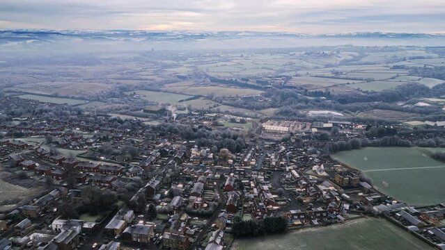 Aerial Drone Video Footage showing a snowy landscape in a suburban UK town.