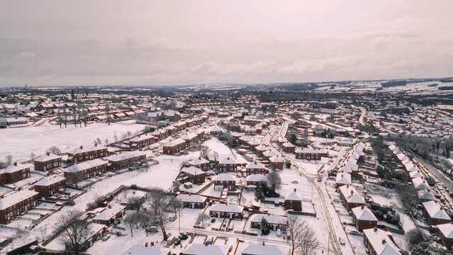 Aerial Drone Video Footage showing a snowy landscape in a suburban UK town.