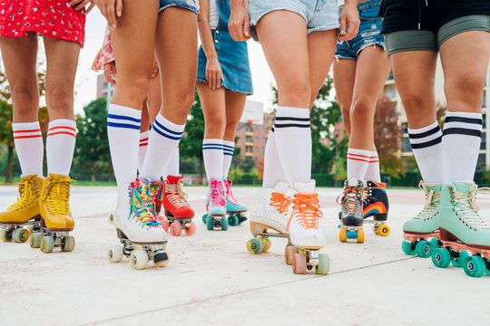 Legs of women practicing roller skating at sports court