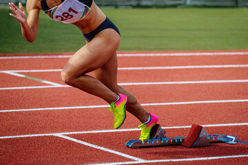 female athlete running from starting blocks sprint race, summer athletics championships