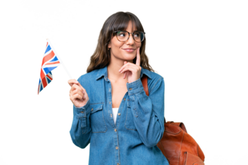 Young caucasian woman holding an United Kingdom flag over isolated background thinking an idea while looking up