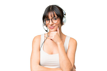 Telemarketer caucasian woman working with a headset over isolated background smiling