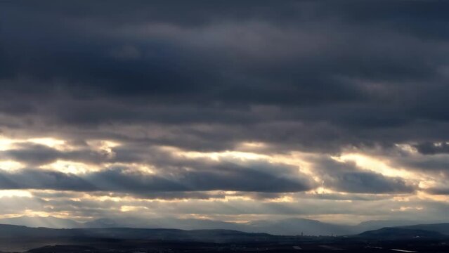 Timelapse sun beams shining through moving dramatic clouds. 