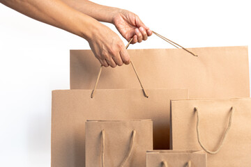 Two anonymous hands taking shopping sale paper bags among several of them arranged in size with a...