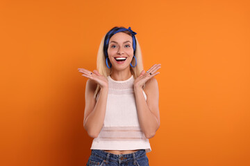 Portrait of excited hippie woman on orange background