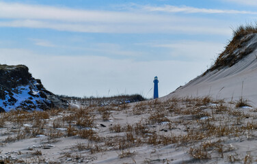 Winter view of Barnegat Lighthouse on the background between sand dunes. Island Beach State Park, Long Beach Island, New Jersey, USA.