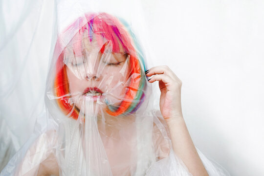 Woman with eyes closed biting plastic