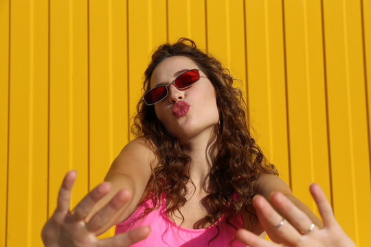 Beautiful woman puckering lips in front of wall