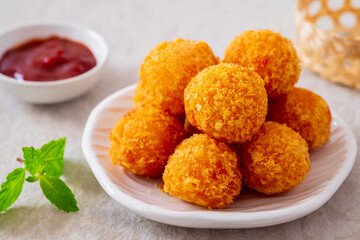 Deep fried cheese balls on plate and ketchup