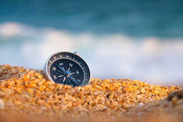 compass on sea sand and place for text. close up of navigation device on sandy beach without...