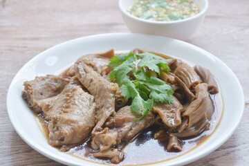 chop boiled duck wing and stew intestine in brown soy soup on plate dipping spicy sauce 