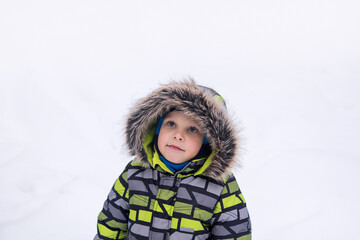 little boy walking in winter snowy park