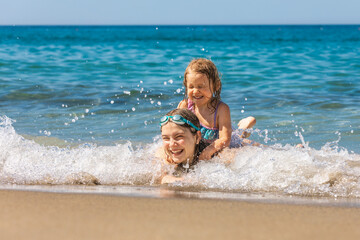 Joyful children playing in the shallow beach waves