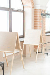 Painting easels with a blank sheet stand by the window
