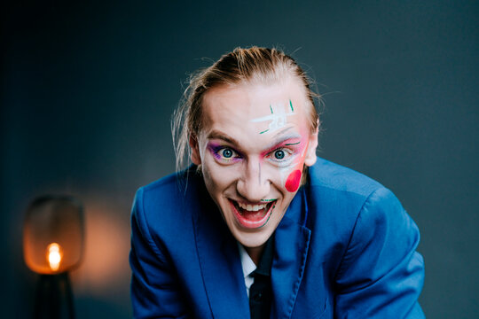Cheerful young man clown make-up on face