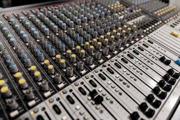 Fototapeta premium Mixer control. Music engineer. Backstage controls on an audio mixer, Sound mixer. Professional audio mixing console with lights, buttons, faders and sliders. sound check for concert. 