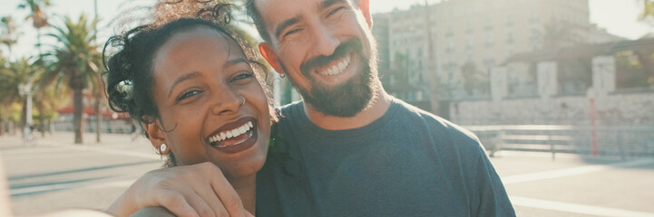 Close-up of interracial smiling couple in love taking selfie, Backlight, Panorama