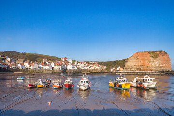 Staithes, North Yorkshire - Fishing boats grounded at low tide in the harbour.