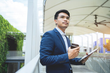 Fototapeta premium Asian businessman uses a laptop computer to work in an office building. Successful financial business ideas.