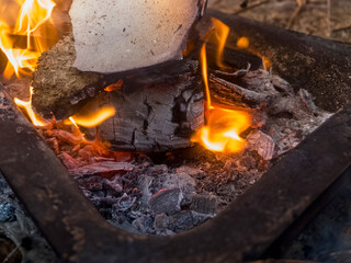 A close up of the a flame wood in bonfire. camp barbecue wood charcoal. wood that burns in the...
