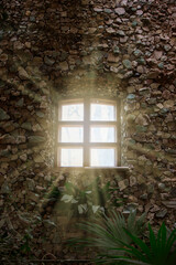 Rays of sunlight from the windows of an ancient stone building.