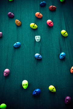 Different colorful carnival masks scattered on a green background.