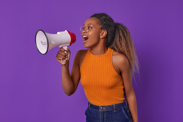 Young optimistic loud African American woman student shouts into megaphone about issuing grant for...