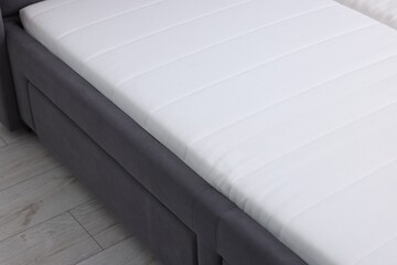 Comfortable bed with new soft mattress indoors