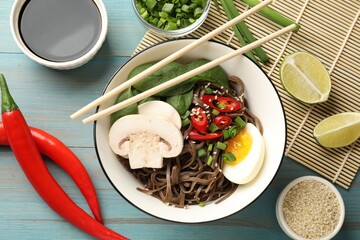 Flat lay composition with tasty buckwheat noodles (soba) and chopsticks on light blue wooden table