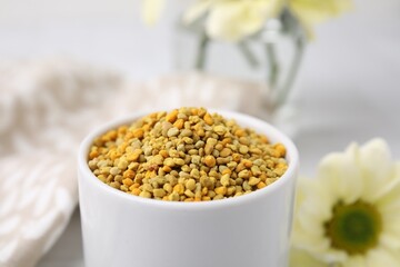Fresh bee pollen granules on blurred background, closeup