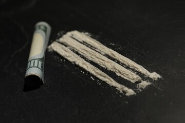 Drug addiction. Cocaine and rolled dollar banknote on grey textured table, closeup