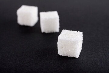  White sugar cubes on black background