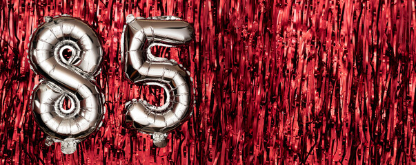 Silver foil balloon number eighty-five. Birthday or anniversary card with the inscription 85....