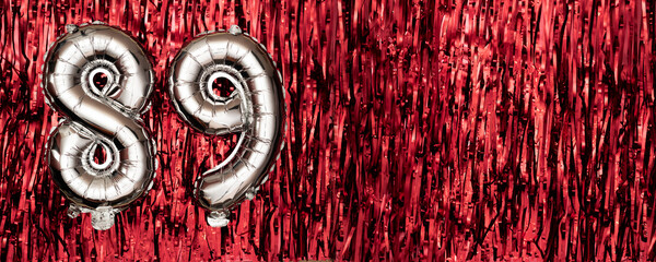 Silver foil balloon number eighty-nine. Birthday or anniversary card with the inscription 89....