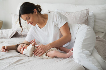 Home portrait of a newborn baby with mother on the bed