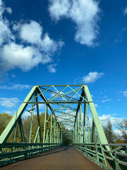 Bridge over the river. Structure of a metal bridge in the city with a blue sky.