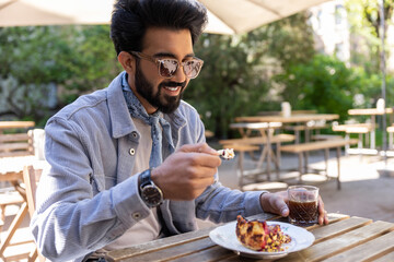 Bearded hindu man sitting at the table and eating unch