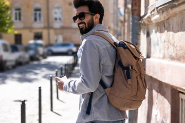 Young hindu man with a backpack roaming about the city