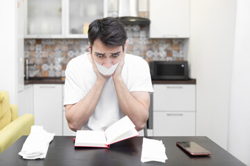 Close up of unhappy man sitting at the table, stressed and confused by calculate expense from...