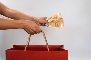 Close-up of action carried out when purchasing on sales, one hand picking up the shopping bag by...