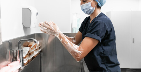 Surgeon having her hands surgically washed. A Caucasian doctor dressed in his right-hand profile with her hands full of foam and dressed in her surgical uniform. 