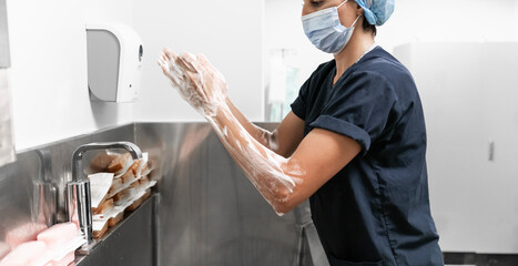 Surgeon having her hands surgically washed. A Caucasian doctor dressed in his right-hand profile with her hands full of foam and dressed in her surgical uniform. 