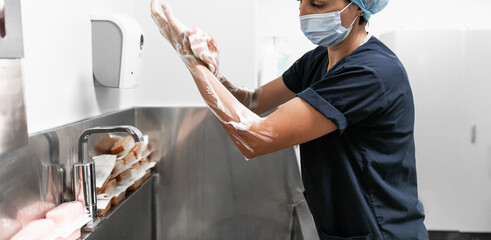 Surgeon having her hands surgically washed. A Caucasian doctor dressed in his right-hand profile...