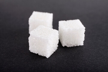  White sugar cubes on black background