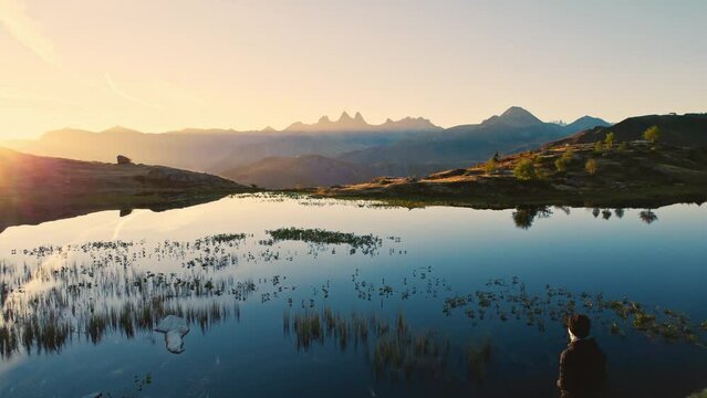 Sunrise shines over Lac Guichard with Arves massif and lake reflection in autumn at French Alps, France
