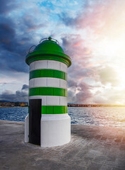 Green striped stone lighthouse in the port. Croatia, Zadar.