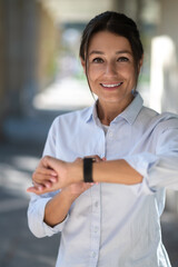 Excited woman looking at the watch and waiting for someone